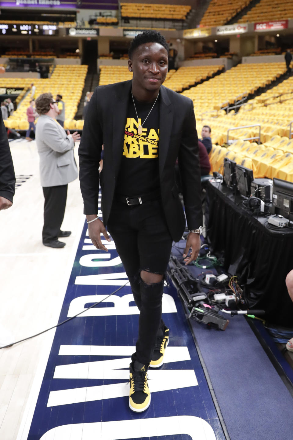 Injured Indiana Pacers guard Victor Oladipo (4) walks down the sideline during warmups before Game 4 of an NBA basketball first-round playoff series against the Boston Celtics in Indianapolis, Sunday, April 21, 2019. (AP Photo/Michael Conroy)