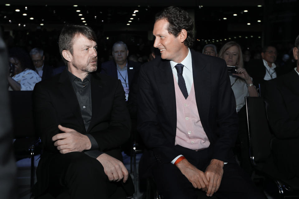 FILE - In this Monday, Jan. 14, 2019 file photo, Mike Manley, left, Chief Executive Officer of Fiat Chrysler Automobiles N.V. talks with John Elkann, Chairman of Fiat Chrysler Automobiles N.V. during media previews for the North American International Auto Show in Detroit. PSA Peugeot’s takeover of Fiat Chrysler to form the world’s fourth-largest carmaker has had its first executive casualty, with former Fiat Chrysler CEO Mike Manley stepping down as his role of head of the Americas. Stellantis announced Tuesday, Sept. 21, 2021 that Manley, 57, was leaving to become CEO of the largest dealership network in the United States, AutoNation Inc., based in Florida. (AP Photo/Paul Sancya, File)