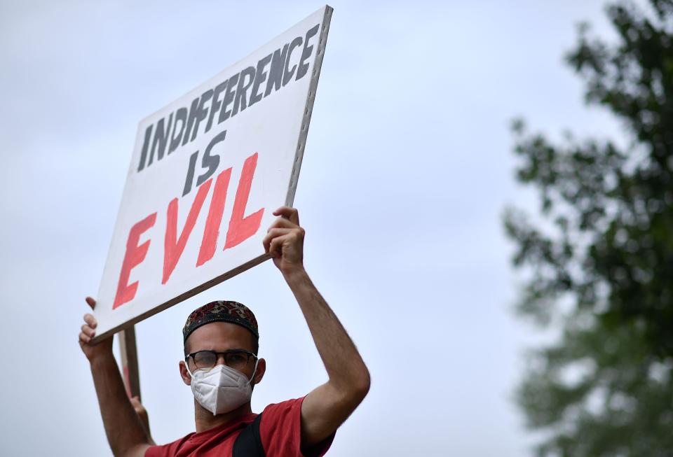 <i>Protester holds a sign that says "Indifference is evil" during an anti-racism demonstration in London on June 3. </i>