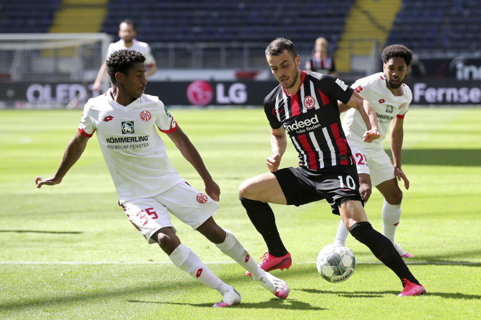 Mainz's Leandro Barreiro Martins, left, challenges Eintracht's Filip Kostic during the German Bundesliga soccer match between Eintracht and Mainz, in Frankfurt, Germany, Saturday, June 6, 2020. Because of the coronavirus outbreak all soccer matches of the German Bundesliga take place without spectators. (Alexander Hassenstein/Pool Photo via AP)