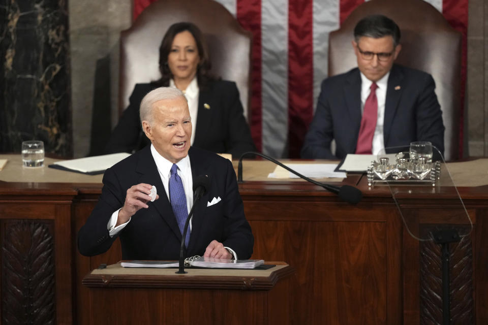 President Joe Biden holds a Laken Riley Botton as delivers the State of the Union address to a joint session of Congress at the U.S. Capitol, Thursday March 7, 2024, in Washington, while Vice President Kamala Harris and House Speaker Mike Johnson of La., watch. (AP Photo/Andrew Harnik)