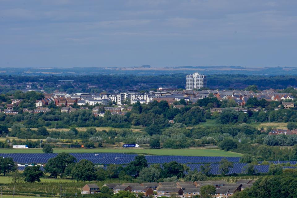 A view of Swindon showing Wroughton in foreground, solar farm, M4 motorway and the sprawling town of Swindon stretching to the horizon including the iconic DMJ Tower.