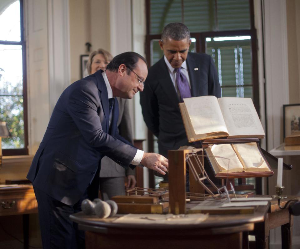 President Barack Obama, right, watches as French President Francois Hollande, left, looks over items on on the desk during a tour of Thomas Jefferson's office at Monticello, Monday, Feb. 10, 2014, in Charlottesville, Va. Leading the tour is Leslie Bowman, president of the Thomas Jefferson Foundation. (AP Photo/Pablo Martinez Monsivais)