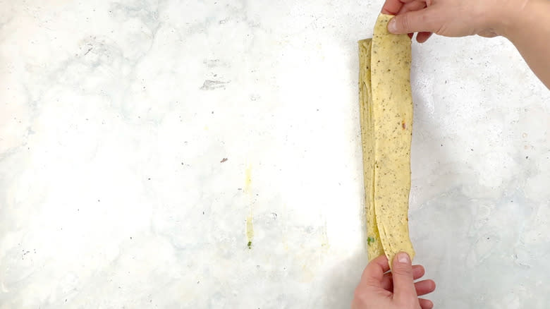 hands stacking dough strips