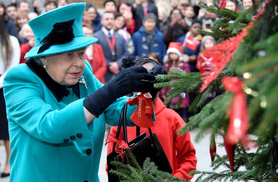 Britain's Queen Elizabeth and Shylah Gordon, aged 8, attach a bauble to a Christmas tree during a visit to children's charity Coram in London, Britain, December 5, 2018. REUTERS/Toby Melville     TPX IMAGES OF THE DAY