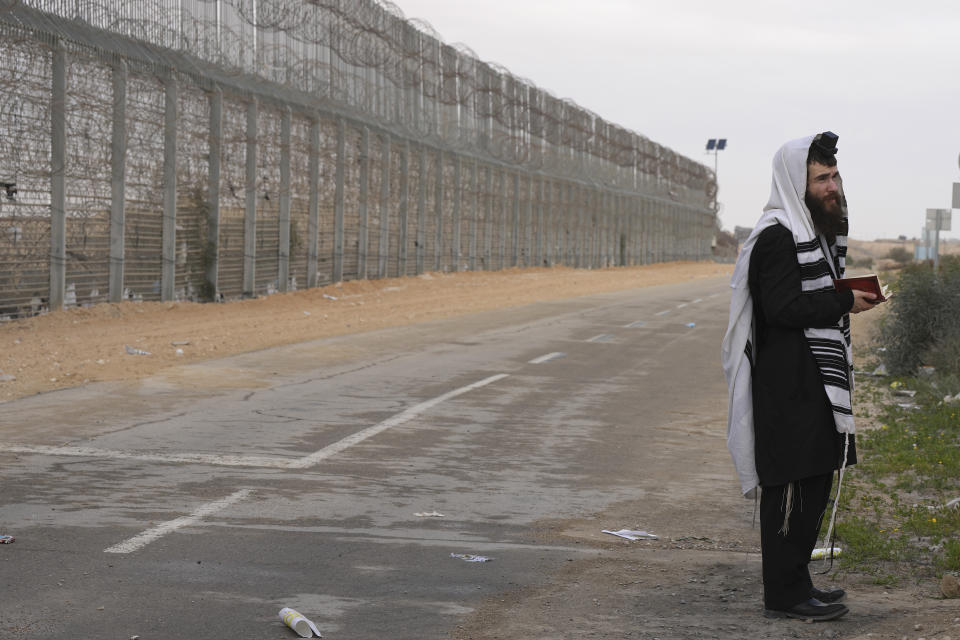 A protesters wears a Jewish prayer shawl as Israelis block humanitarian aid bound for the Gaza Strip at the Nitzana border crossing with Egypt in southern Israel Friday, Feb. 2, 2024. (AP Photo/Tsafrir Abayov)