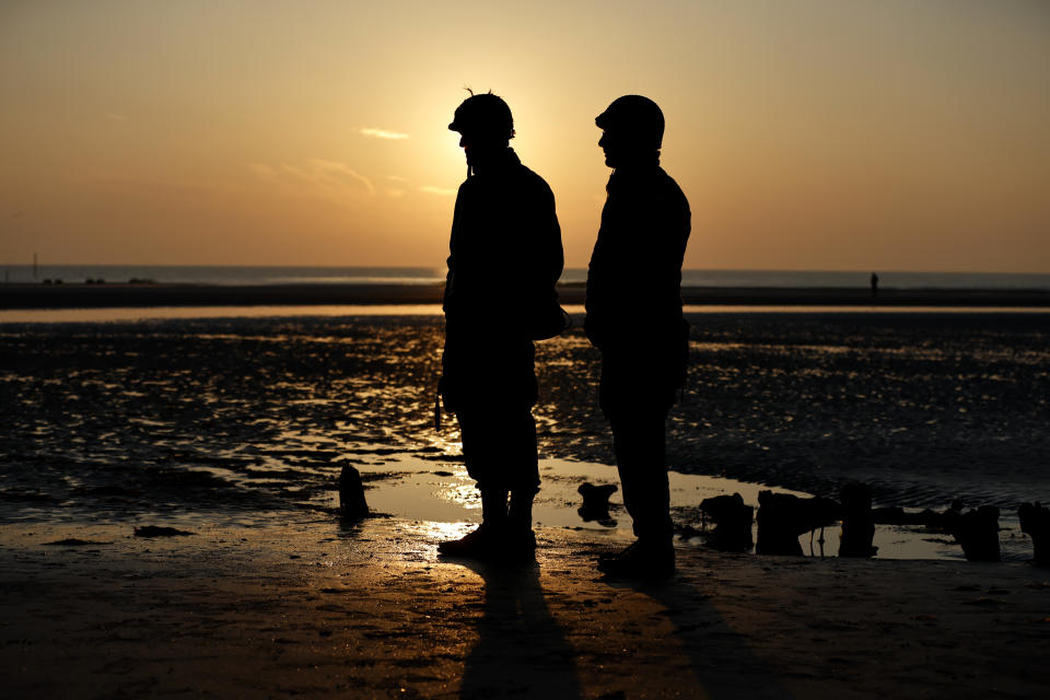 Re enactors are sillhouetted against the sunrise at Utah Beach near Saint-Martin-de-Vareville Normandy, Thursday, June 6, 2024. World War II veterans from across the United States as well as Britain and Canada are in Normandy this week to mark 80 years since the D-Day landings that helped lead to Hitler's defeat. (AP Photo/Jeremias Gonzalez)