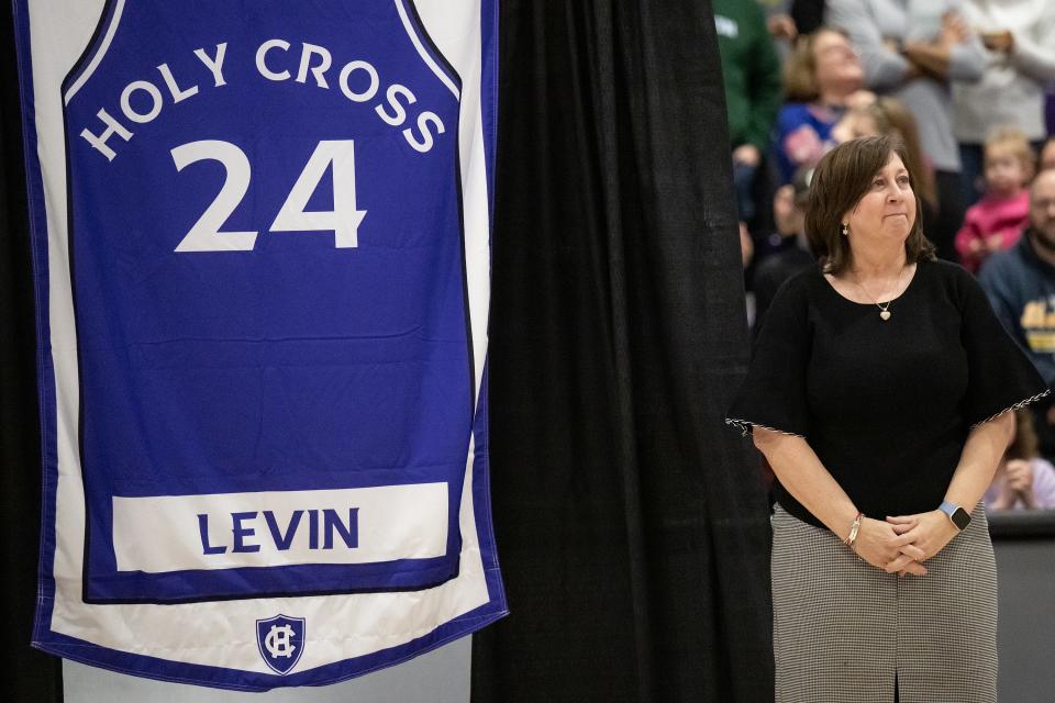 Sherry Levin '84, stands with her jersey during Saturday's ceremony retiring the numbers of former Holy Cross women's basketball players.