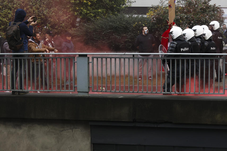 Police officers argument with protestors during a demonstration against the reinforced measures of the Belgium government to counter the latest spike of the coronavirus in Brussels, Belgium, Sunday, Nov. 21, 2021. Many among them also protested against the strong advice to get vaccinated and any moves to impose mandatory shots. (AP Photo/Olivier Matthys)