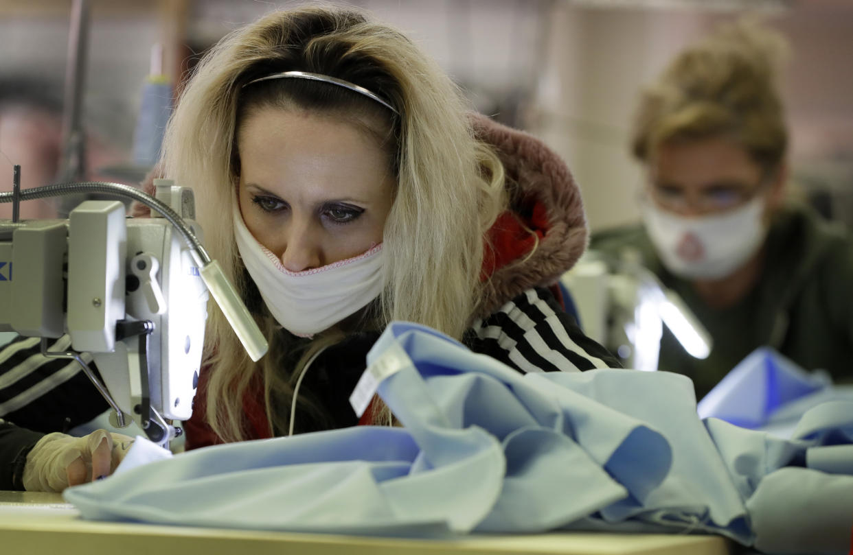 Machinists concentrate as they work to sew scrubs for the NHS at the factory of Fashion Enter in London, as the country is in lockdown to help curb the spread of the coronavirus, Friday, April 3, 2020. The company normally makes fashion garments for Asos, but the shortages within the NHS mean that they have put their fashion orders on hold whilst they make PPE (personal protective equipment) to protect workers against the coronavirus outbreak. (AP Photo/Kirsty Wigglesworth)