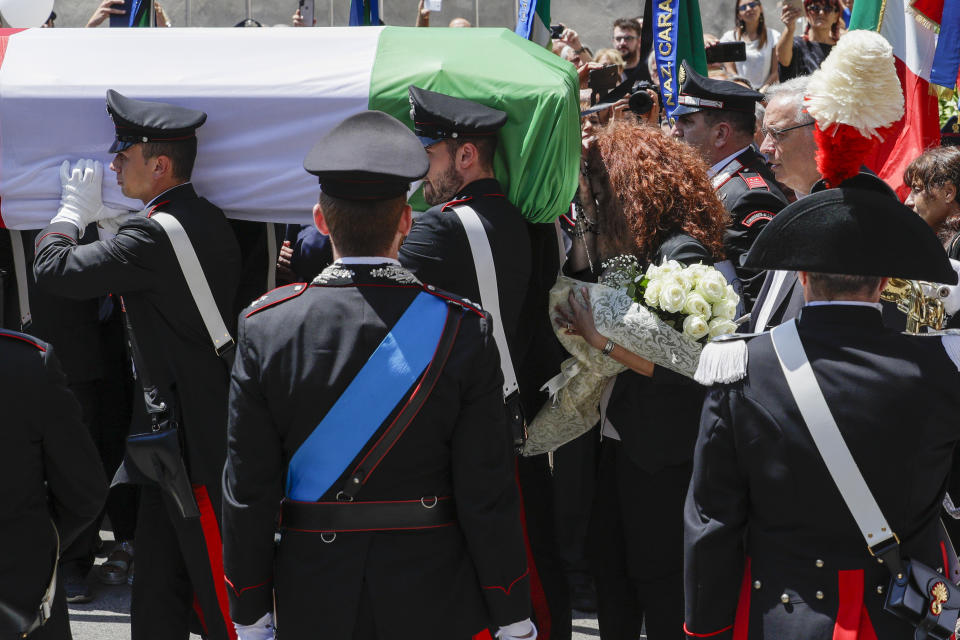 Carabinieri officer Mario Cerciello Rega's wife, Rosa Maria, right, follows the coffin containing the body of her husband during his funeral in his hometown of Somma Vesuviana, near Naples, southern Italy, Monday, July 29, 2019. Two American teenagers were jailed in Rome on Saturday as authorities investigate their alleged roles in the fatal stabbing of the Italian police officer on a street near their hotel. (AP Photo/Andrew Medichini)