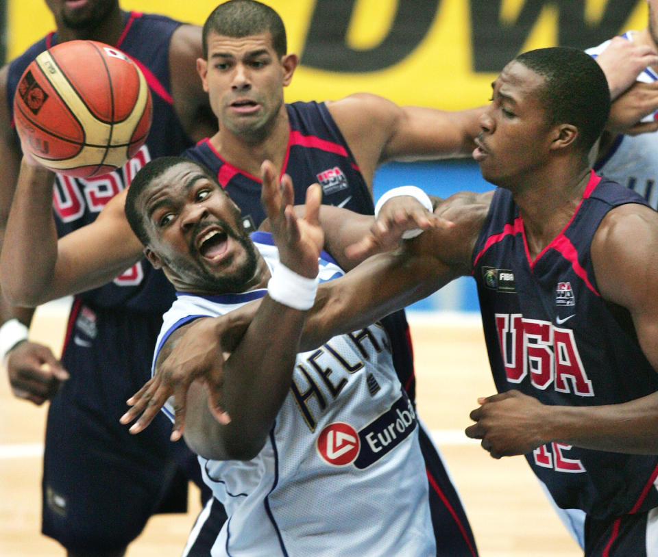 FILE - In this Sep. 1, 2006, file photo, Greece's Sofoklis Schortsiantis, left, drives to the basket as USA's Dwight Howard (12), right, NBA's Orlando Magic, and Shane Battier, of NBA's Memphis Grizzlies, ceneter back, guard during the semifinals of the World Basketball Championships in Saitama, Japan. The 2006 world championship was perhaps the last truly wide-open international basketball event. Argentina arrived as the Olympic champion and Spain left as the world champion, the last time for a long while anyone other than the U.S. would hold either title. (AP Photo/Itsuo Inouye, File)