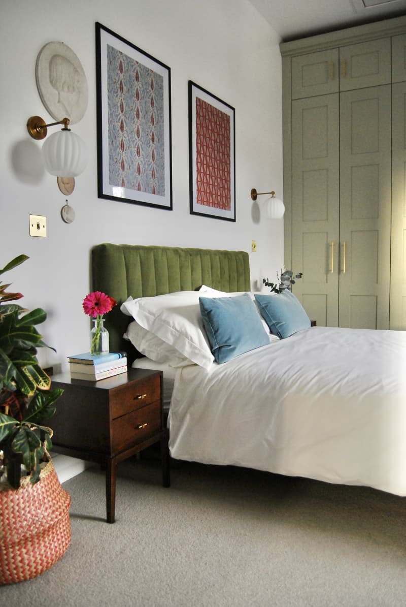 Bed with green velvet headboard.