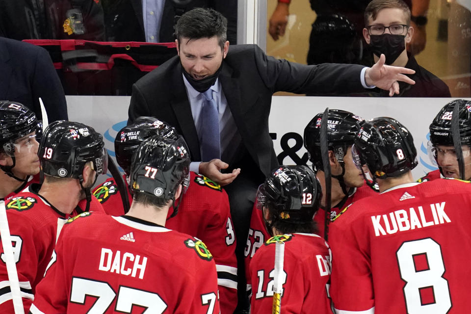 Chicago Blackhawks head coach Jeremy Colliton, top center, talks to his team during the third period of an NHL hockey game against the Detroit Red Wings in Chicago, Sunday, Oct. 24, 2021. (AP Photo/Nam Y. Huh)