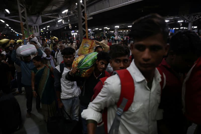 21-year-old aspiring college student and migrant worker Sujeet Kumar carries his luggage as he exits Thane railway station on the outskirts of, Mumbai,