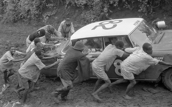 tough conditions in the Safari Rally - people push a car that became bogged down in mud - Mario De Biasi/Mondadori