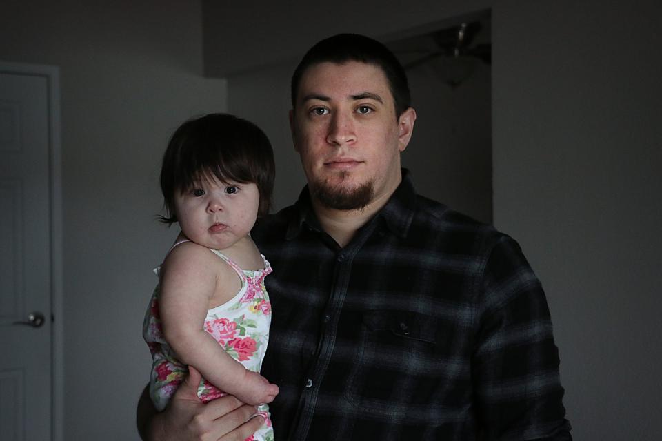 Elijah Johnson poses for a portrait with his daughter Azriela-Nova in their apartment in Reno on March 28, 2023.