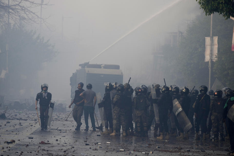 Police use water cannon to disperse supporters of former Prime Minister Imran Khan during clashes, in Lahore, Pakistan, Wednesday, March 15, 2023. Clashes between Pakistan's police and supporters of Khan persisted outside his home in the eastern city of Lahore on Wednesday, a day after officers went to arrest him for failing to appear in court on graft charges. (AP Photo/K.M. Chaudary)