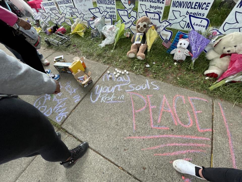 Crowds of people chalk down the Landon Street sidewalk with words of condolences Tuesday, May 17, 2022 in Buffalo, New York.