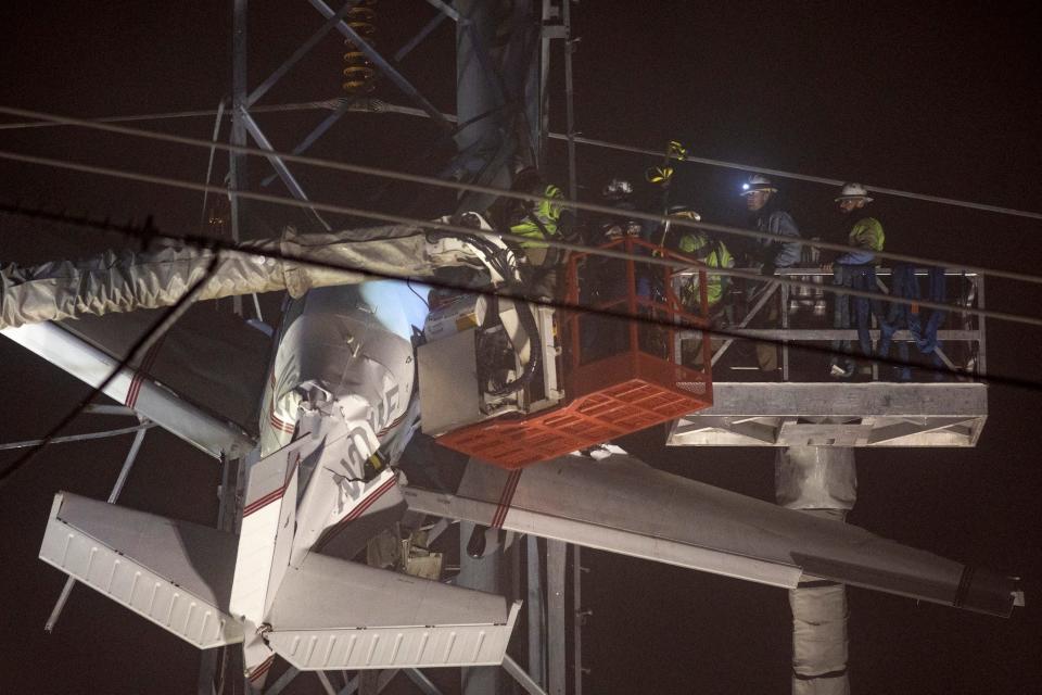 A small plane rests on live power lines after crashing, Sunday, November 27, 2022.