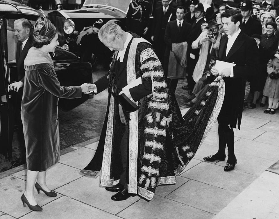 Queen Elizabeth II meets British Prime Minister Harold Macmillan (1894 - 1986), Chancellor of Oxford University, outside the Clarendon Building during a visit to Oxford, 4th November 1960. The PM's pageboy is his grandson Alexander Macmillan, later the 2nd Earl of Stockton. (Photo by Terry Disney/Central Press/Getty Images)