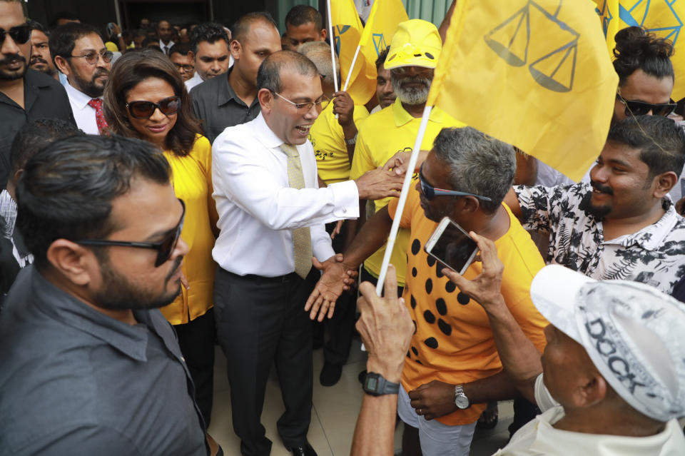 Maldives’ former president Mohamed Nasheed, center, greets supporters and party workers upon arrival at the airport in Male, Maldives, Thursday, Nov.1, 2018. Nasheed The first democratically elected president of the Maldives returned home after more than two years in exile to escape a long prison term. (AP Photo/Mohamed Sharuhaan)