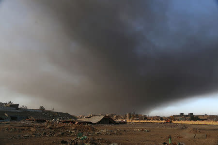 Smoke rises from oil wells set ablaze by Islamic State militants before fleeing the oil-producing region of Qayyara, Iraq, January 15, 2017. Picture taken January 15, 2017. REUTERS/Girish Gupta