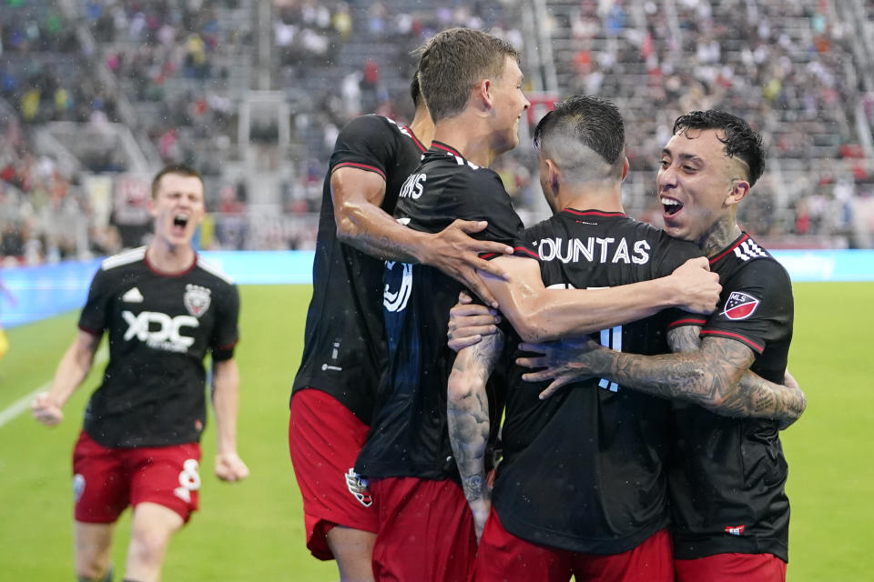 D.C. United players celebrate after forward Taxiarchis Fountas, second from right, scored a goal against Orlando City during the second half of an MLS soccer match, Sunday, July 31, 2022, in Washington. D.C. United won 2-1. (AP Photo/Julio Cortez)