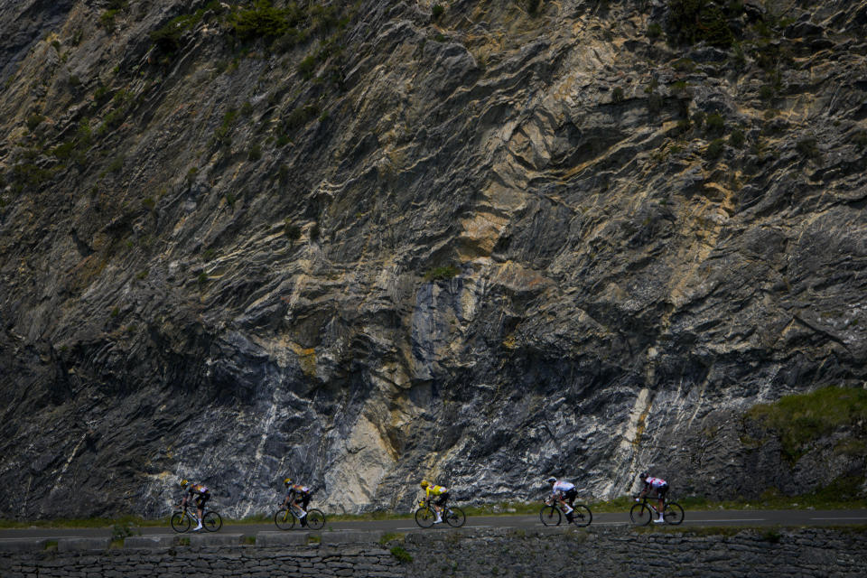 Denmark's Jonas Vingegaard, wearing the overall leader's yellow jersey, and Slovenia's Tadej Pogacar, wearing the best young rider's white jersey, speed downhill during the eighteenth stage of the Tour de France cycling race over 143.5 kilometers (89.2 miles) with start in Lourdes and finish in Hautacam, France, Thursday, July 21, 2022. (AP Photo/Daniel Cole)