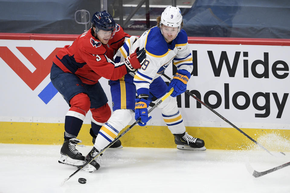 Buffalo Sabres center Jack Eichel (9) and Washington Capitals defenseman Nick Jensen (3) battle for the puck during the second period of an NHL hockey game, Friday, Jan. 22, 2021, in Washington. (AP Photo/Nick Wass)