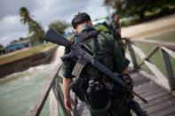 Malaysian armed policemen patrol near Lahad Datu, on the Malaysian island of Borneo on February 16, 2013. Three people including two police officers were killed Friday as Malaysian security forces moved in to end a 17-day stand-off with armed Filipino intruders on Borneo island, the Philippine government said