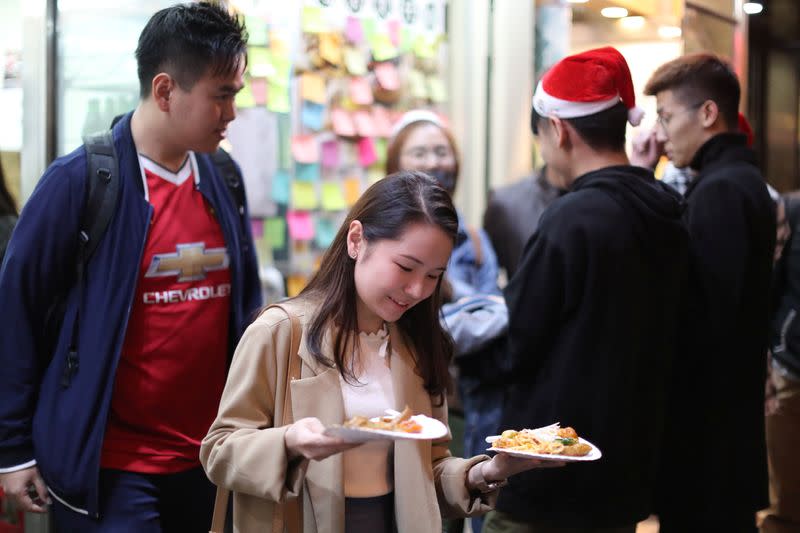 Protesters queue for a free Christmas dinner offered by a local restaurant in Hong Kong