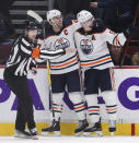 Edmonton Oilers' Connor McDavid, left, and Ryan Nugent-Hopkins celebrate McDavid's winning goal against the Vancouver Canucks during overtime in an NHL hockey game, Tuesday, Jan. 25, 2022 in Vancouver, British Columbia. (Darryl Dyck/The Canadian Press via AP)