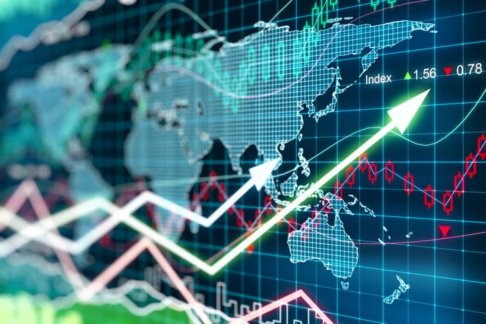 Stock market charts indicating gains, overlaying a digital world map.