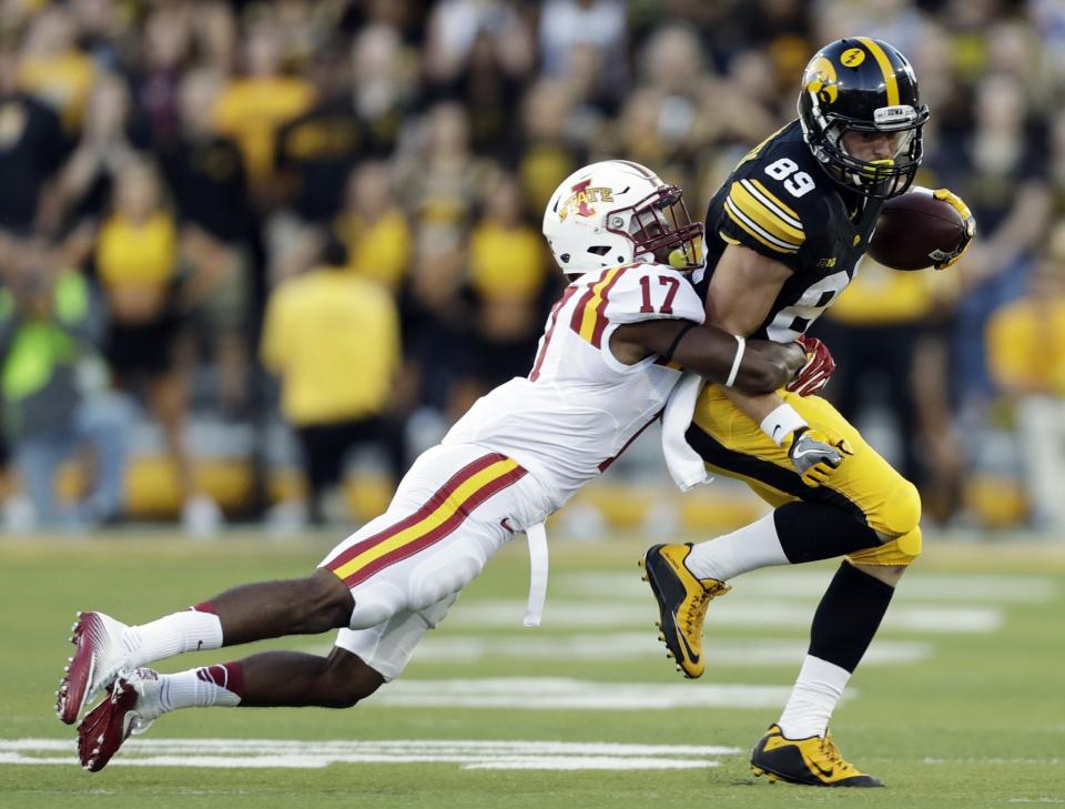 Iowa wide receiver Matt VandeBerg, right, tries to break a tackle by Iowa State defensive back Jomal Wiltz. (AP Photo/Charlie Neibergall)