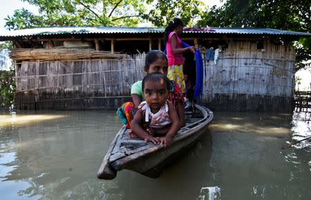 Villagers use a boat as they try to move to safer places at a flood-affected village in Darrang district in the northeastern state of Assam July 14, 2017. REUTERS/Anuwar Hazarika