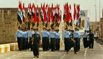 Iraqi security forces parade carrying Iraqi flags during a handover ceremony at the government headquarters in Ramadi, capital of Anbar province, in Iraq Monday, Sept. 1, 2008. The U.S. military handed over control of the once brutally violent Anbar province to Iraqi forces Monday, marking a major milestone in America's plan to eventually send its troops home, but American officials warned that the struggle against insurgents was not over in the western region. (AP Photo/Wathiq Khuzaie, Pool)