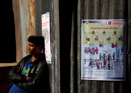 A man stands next to the instruction posters displayed by the Election Commission near the polling station, a day ahead of the parliamentary and provincial elections in Kathmandu, Nepal December 6, 2017. REUTERS/Navesh Chitrakar