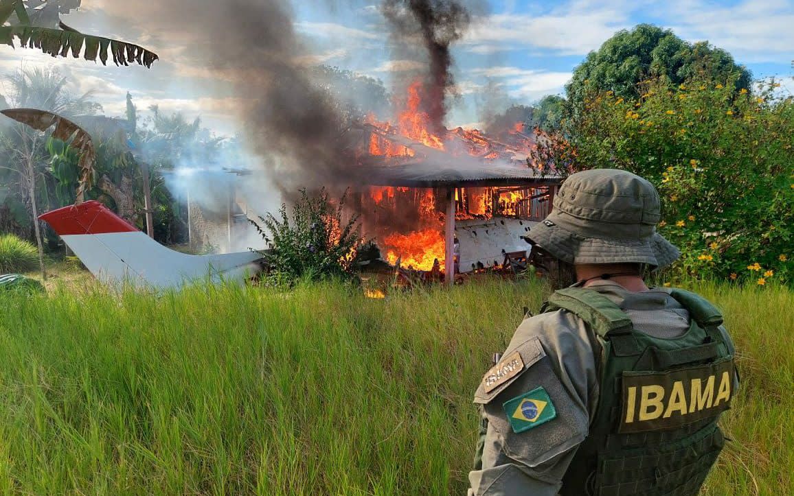 An agent from Ibama watches as an aircraft burns as they expel illegal miners from the area - Ibama/Shutterstock