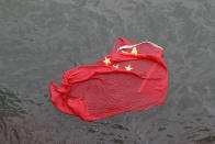 A Chinese flag floats on the surface it was thrown in the water by protesters during a demonstration in Hong Kong, Saturday, Aug. 3, 2019. Hong Kong protesters ignored police warnings and streamed past the designated endpoint for a rally Saturday in the latest of a series of demonstrations targeting the government of the semi-autonomous Chinese territory. (AP Photo/Vincent Thian)