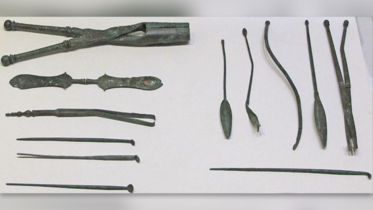  Ancient medical instruments displayed on a white background. 