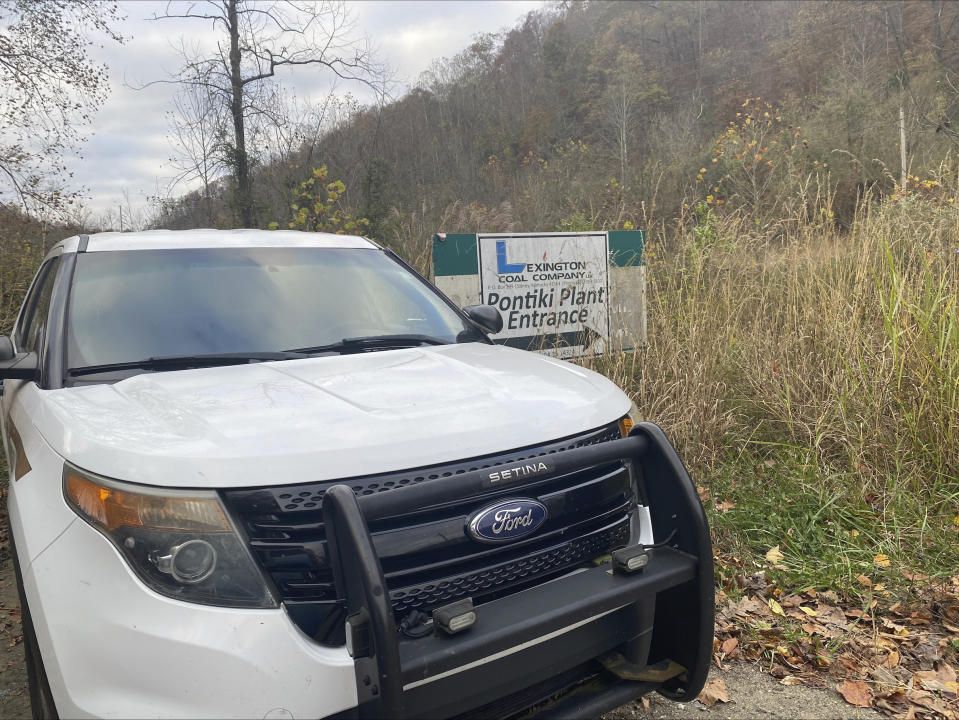 In this image provided by WCHS-TV, a Martin County, Ky., sheriff's cruiser is shown outside an abandoned mine coal preparation plant Wednesday, Nov. 1, 2023, south of Inez, Ky. One man has died after he and a coworker were trapped beneath a collapsed 11-story building being demolished at the abandoned eastern Kentucky mine's coal preparation plant, Gov. Andy Beshear announced Wednesday. (Hannah Cline/WCHS-TV via AP)