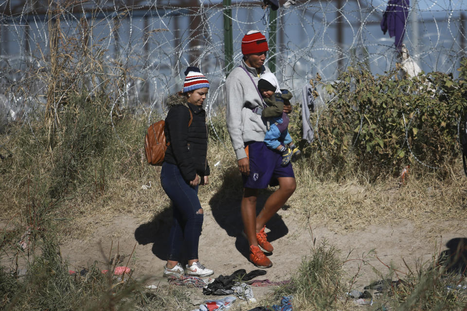 Migrantes con un bebé caminan hacia el lado estadounidense de la frontera desde Ciudad Juárez, México, el 27 de diciembre de 2023. (AP Foto/Christian Chávez)