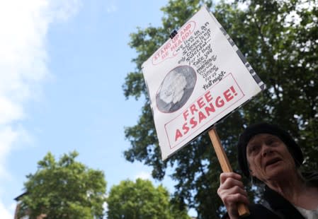 A demonstrator holding a placard protests outside of Westminster Magistrates Court, where a case hearing for U.S. extradition of Wikileaks founder Julian Assange is held, in London