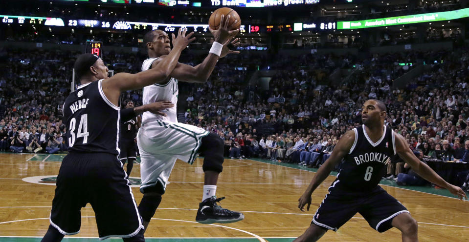 Brooklyn Nets forward Paul Pierce, left, defends Boston Celtics guard Rajon Rondo on a drive to the basket during the first quarter of an NBA basketball game, Friday, March 7, 2014, in Boston. At right is Nets forward Alan Anderson. (AP Photo/Charles Krupa)