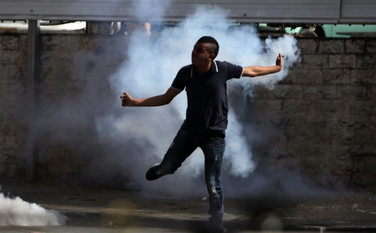 A Palestinian youth runs through tear gas during clashes with Israeli soldiers in al-Ram, near Ramallah, following a protest after security forces entered the al-Aqsa mosque compound in Jerusalem on September 15, 2015