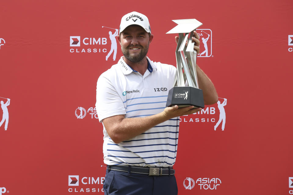 Marc Leishman of Australia poses with his trophy after winning the CIMB Classic golf tournament at Tournament Players Club (TPC) in Kuala Lumpur, Malaysia, Sunday, Oct. 14, 2018. (AP Photo/Vincent Phoon)