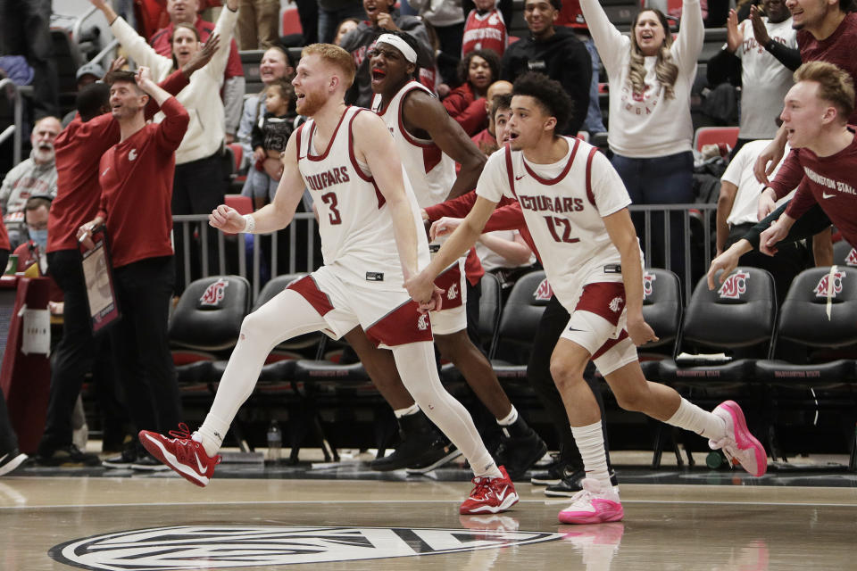 Washington State guards Jabe Mullins (3), Isaiah Watts (12) and teammates celebrate after their win over Arizona in an NCAA college basketball game, Saturday, Jan. 13, 2024, in Pullman, Wash. (AP Photo/Young Kwak)