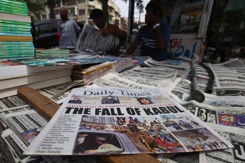 People read front-page news of the Taliban taking over Kabul at a newspaper stall in Karachi, Pakistan, 16 August 2021. (Shahzaib Akber/EPA-EFE/Shutterstock)