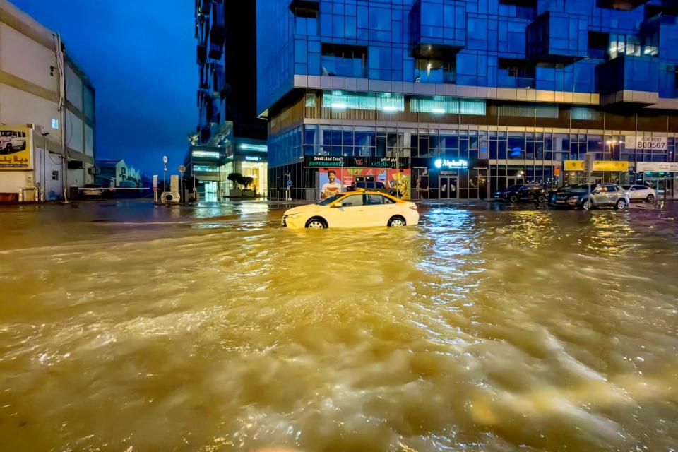 PHOTO: A taxi drives through a flooded street following heavy rains in Dubai early on April 17, 2024. (Giuseppe Cacace/AFP via Getty Images)